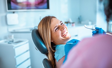 a patient laughing and talking to their dental hygienist