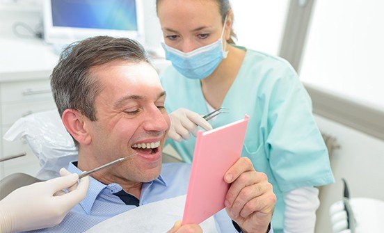 Man looking at smile in mirror