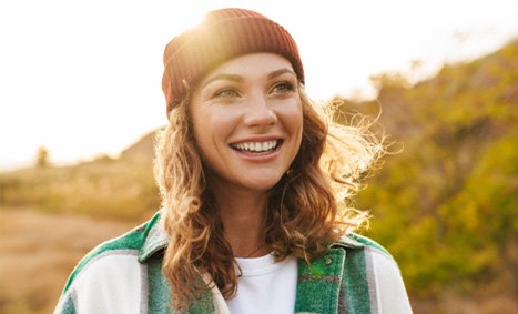 a smiling woman walking outdoors