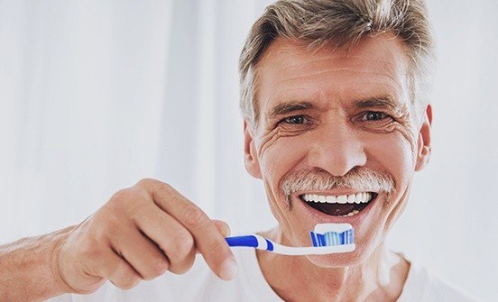 Older man brushing his teeth