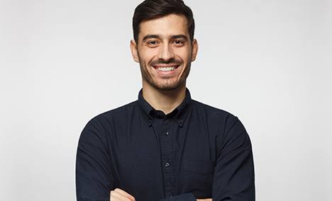 a smiling man wearing a black button down shirt