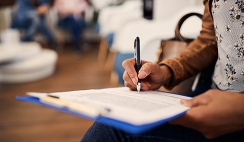 a patient filling out paperwork in a waiting area