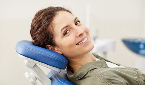a woman sitting in a dental chair smiling