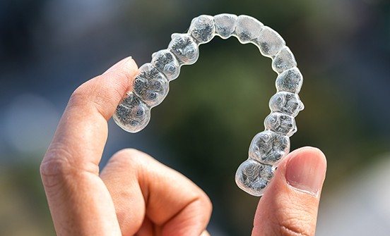 Hand holding a clear aligner