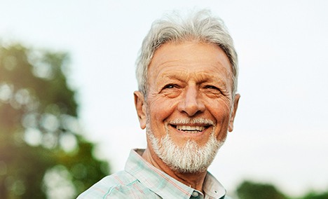 a smiling man standing outdoors