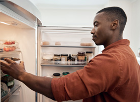 a man looking through the refrigerator 