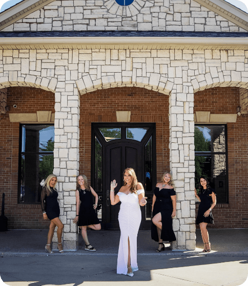 dental team smiling and posing outside of dental office