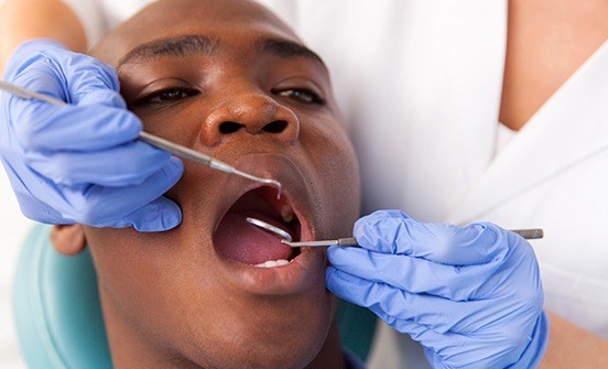 Man receiving oral cancer screening