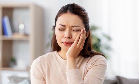 a woman with a toothache holding her mouth