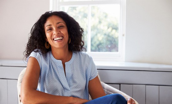 a smiling woman sitting on a chair