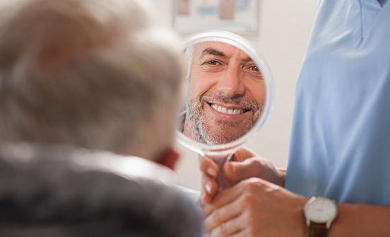 Man looking at smile in mirror