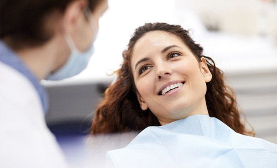 woman smiling while visiting dentist in Clinton Township