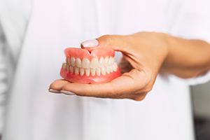 person holding dentures