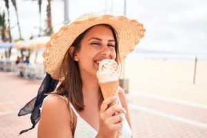 Woman smiling outside while eating ice cream