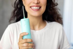 a woman holding a water flosser
